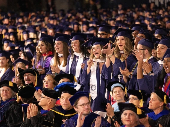 graduates standing in a crowd at commencement