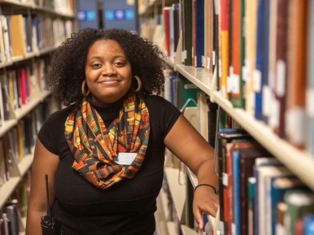 Diona Lumia standing near bookshelves