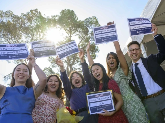 six students holding up signs with their medical residency placements written on them