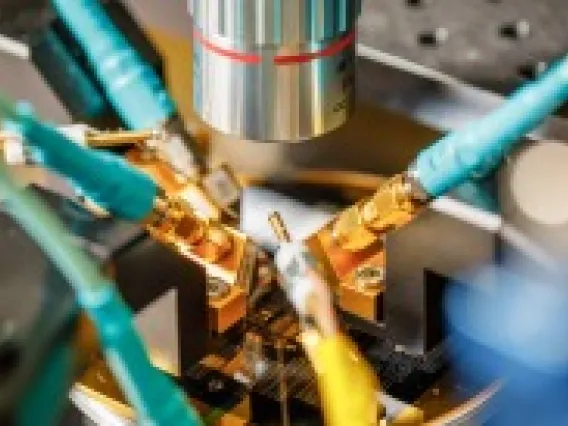 A silicon wafer with a phononic device is being tested under a microscope. 