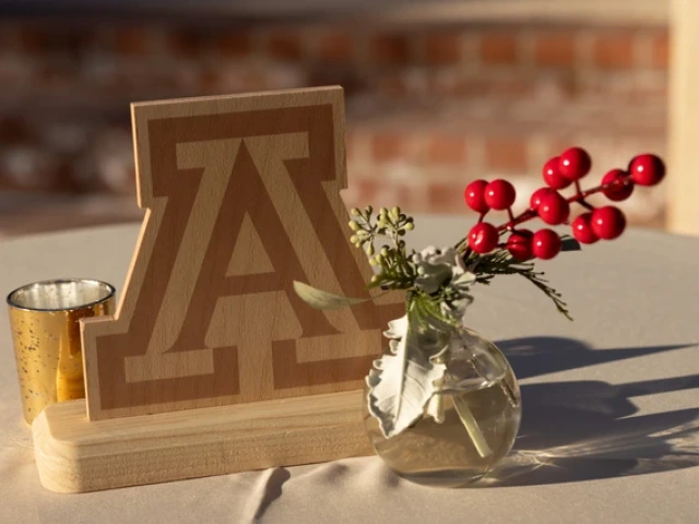 a wooden block A logo with a twig of holly next to it