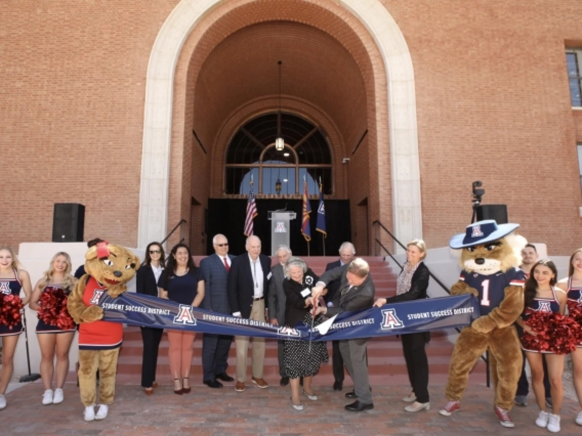 people cutting a ribbon outside the student success district