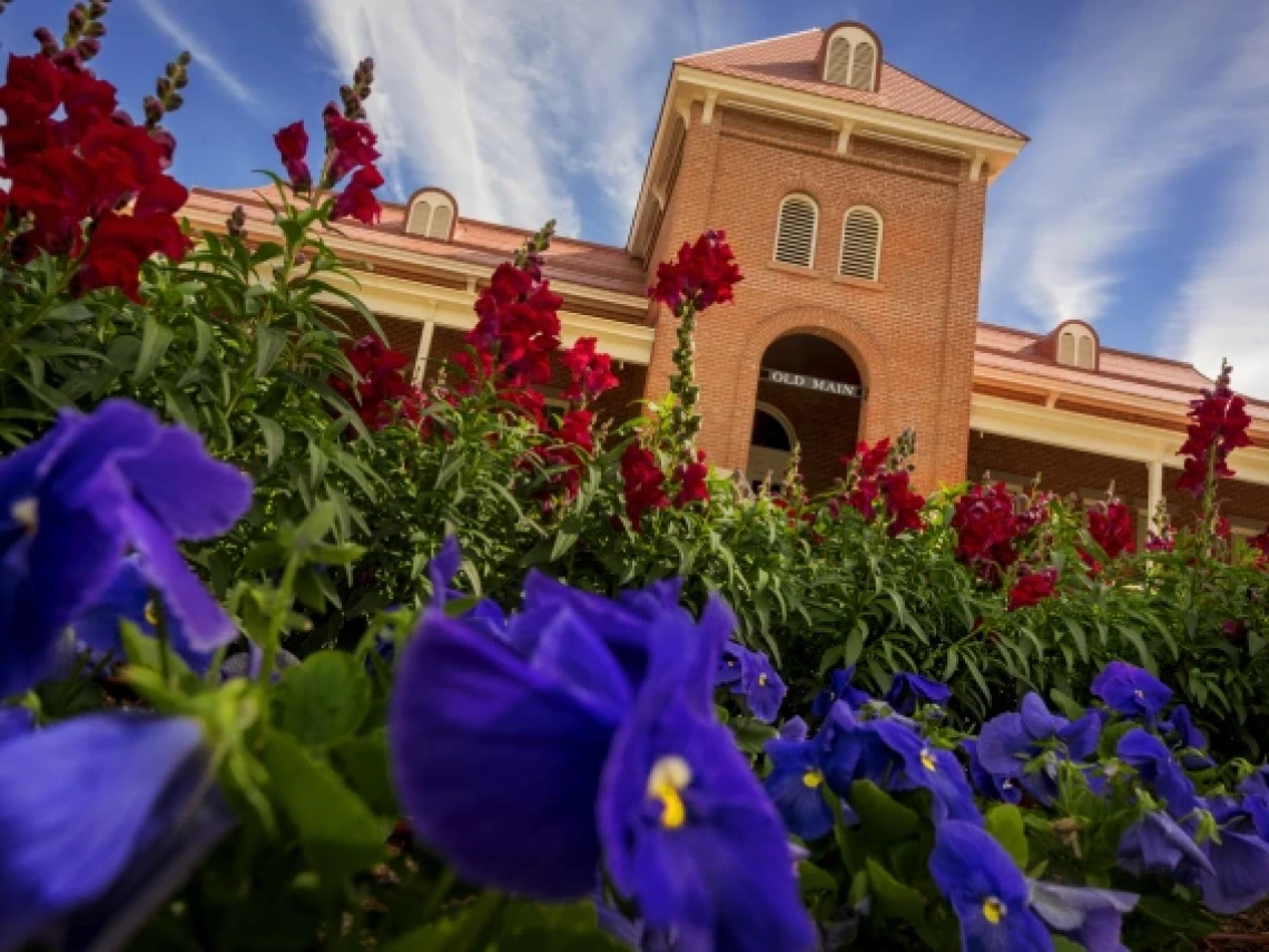 old main with flowers in front of it